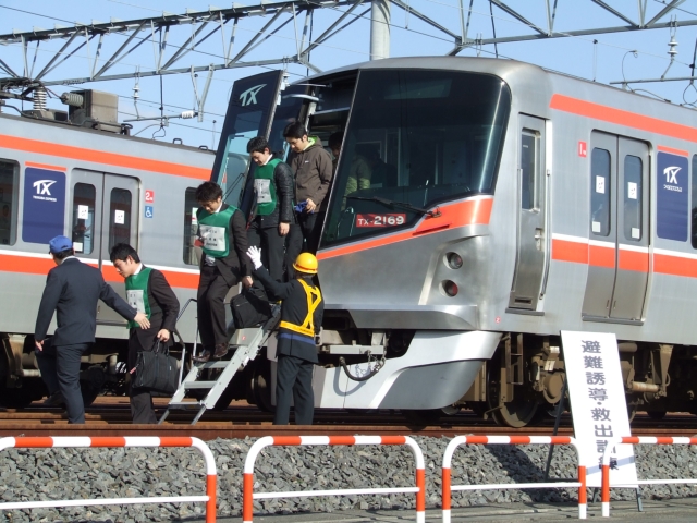 (避難誘導 TX社員を先頭に最寄のみらい平駅へ避難)